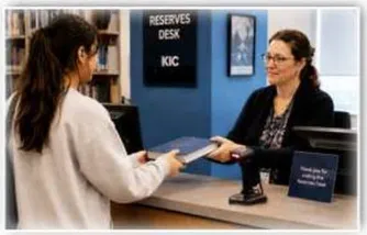 A student returning the book to the Reserves Desk